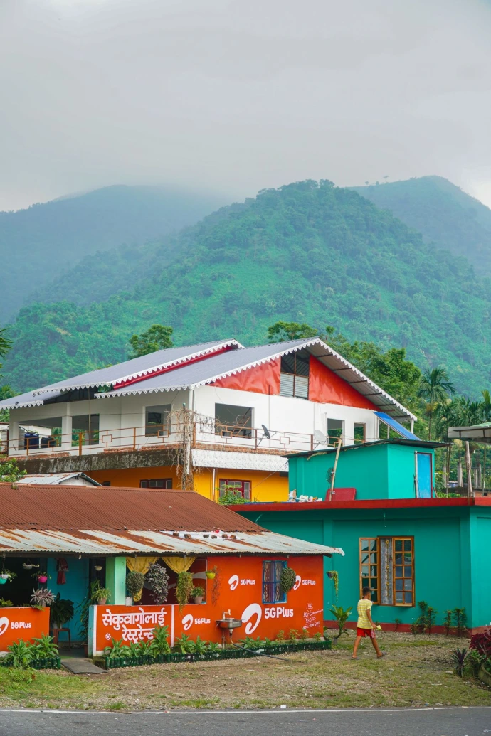 Colorful houses in a mountain village with lush green hills.